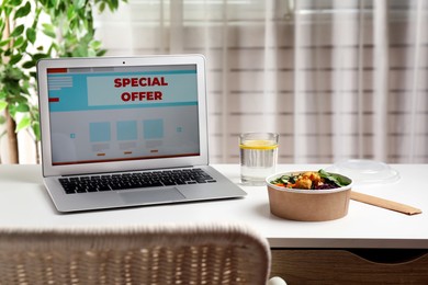 Modern laptop with phrase Special Offer on white table indoors