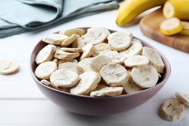 Freeze dried and fresh bananas on white wooden table, closeup