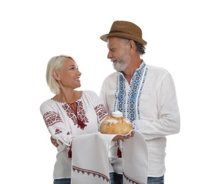 Happy mature couple in national clothes with bread and salt on white background. Ukrainian welcoming tradition