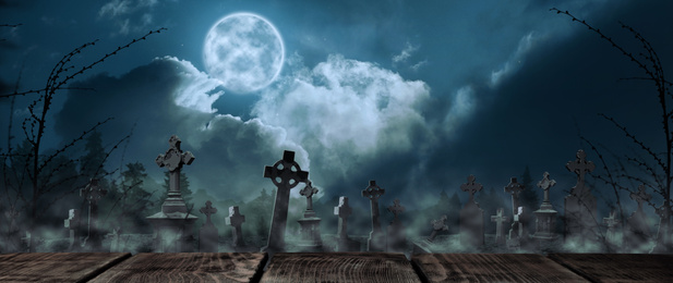 Wooden surface and misty graveyard with old creepy headstones under full moon. Halloween banner design