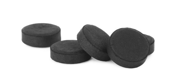 Activated charcoal pills on white background. Potent sorbent