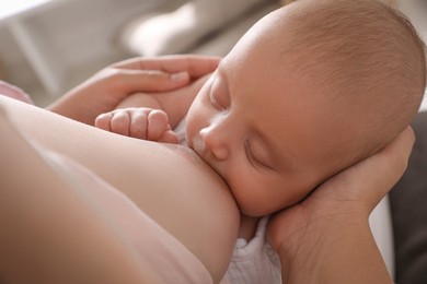 Woman breastfeeding her cute little baby, closeup