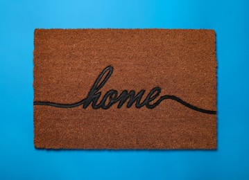 Photo of Doormat with word Home on light blue background, top view