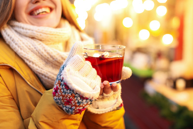 Woman with mulled wine at winter fair, closeup