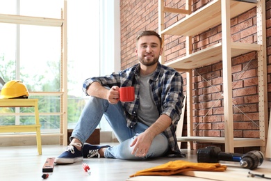 Young working man having coffee break indoors