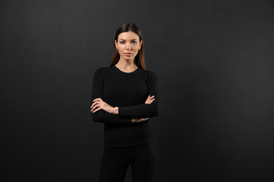 Woman wearing thermal underwear on black background