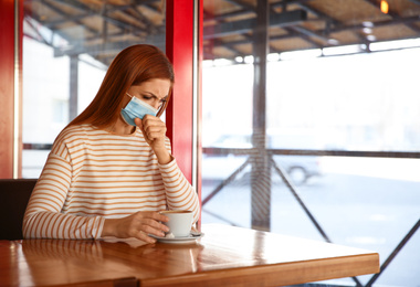 Woman with medical mask in cafe. Virus protection