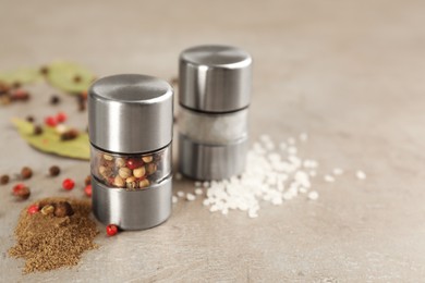 Photo of Salt and pepper shakers on light grey table, closeup. Space for text