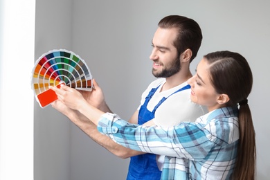 Male decorator and young woman with color palette indoors