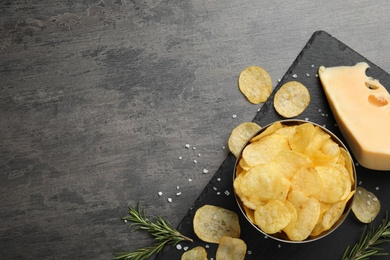 Flat lay composition with delicious crispy potato chips on table, space for text