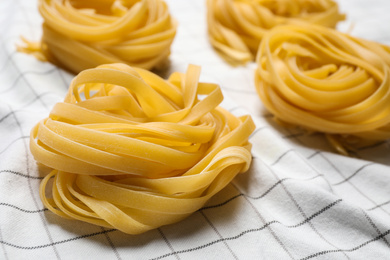 Tagliatelle pasta on white tablecloth, closeup view