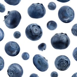 Many fresh ripe blueberries falling on white background