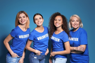 Team of female volunteers in uniform on blue background