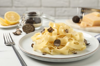 Delicious pasta with truffle slices served on white table