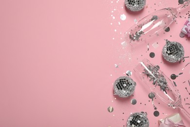 Bright shiny disco balls, confetti and glasses on pink background, flat lay. Space for text