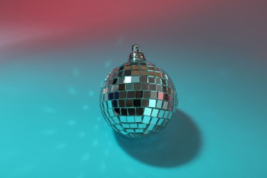 Bright shiny disco ball on color background