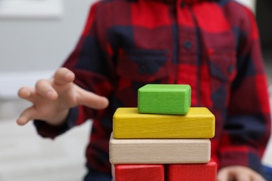 Little child playing with building blocks indoors, closeup