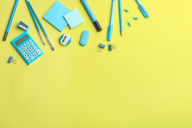Blue school stationery on yellow background, flat lay with space for text. Back to school
