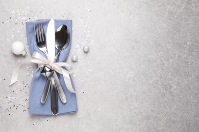 Cutlery set on grey table, top view with space for text. Christmas celebration