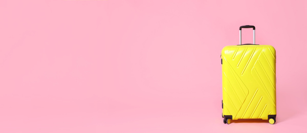 Stylish suitcase on pink background, space for text. Banner design 