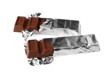 Photo of Delicious chocolate bars wrapped in foil on white background