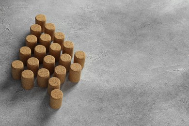 Photo of Christmas tree made of wine corks on grey table. Space for text