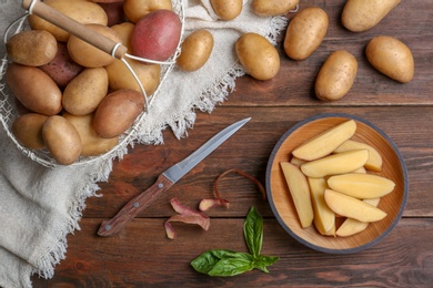 Flat lay composition with fresh organic potatoes on wooden background