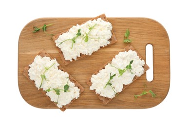Photo of Crispy crackers with cottage cheese and microgreens on white background, top view