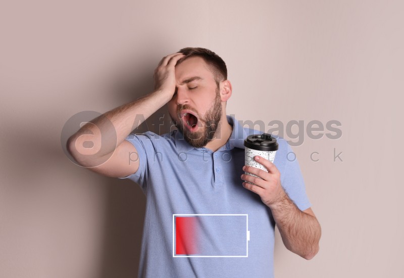 Image of Sleepy man with cup of coffee yawning and illustration of discharged battery on beige background