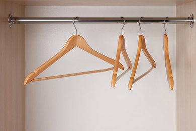 Set of wooden clothes hangers on wardrobe rail