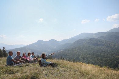 Group of people spending time together in mountains. Space for text