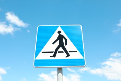Traffic sign Pedestrian Crossing against blue sky, low angle view