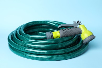 Watering hose with sprinkler on light blue background