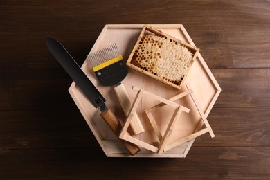 Honeycomb frames and beekeeping tools on wooden table, top view