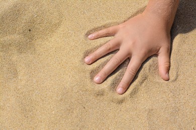 Child leaving handprint on sand outdoors, closeup with space for text. Fleeting time concept