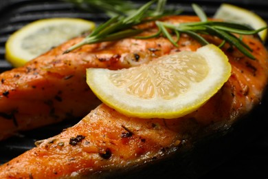 Cooking salmon. Grill with tasty fish steak, lemon and rosemary, closeup