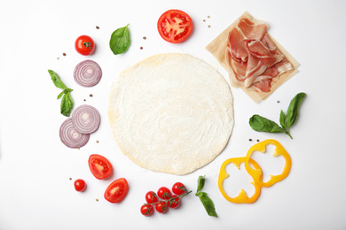 Flat lay composition with dough and fresh ingredients for pizza on white background