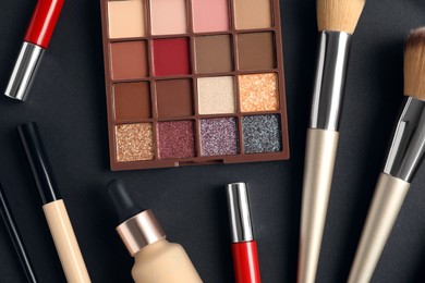 Set of makeup products on dark background, flat lay