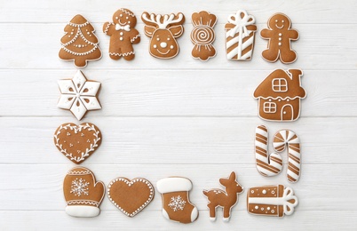 Frame of different Christmas cookies on white wooden table, flat lay. Space for text
