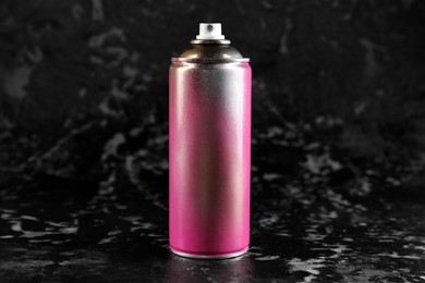 Used can of spray paint on black marble background