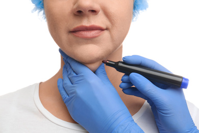 Surgeon with marker preparing woman for operation against white background, closeup. Double chin removal