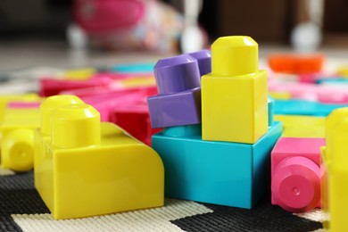 Colorful plastic building blocks on carpet indoors, closeup