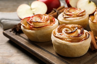 Freshly baked apple roses on wooden table, closeup. Beautiful dessert