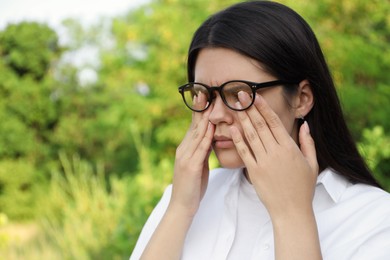 Photo of Young woman suffering from eyestrain outdoors on sunny day