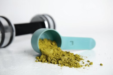 Photo of Measuring scoop with hemp protein powder on white table