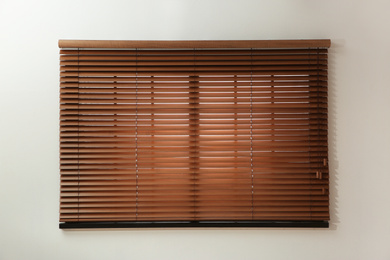 Window with closed brown blinds in room
