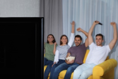 Photo of TV set and blurred people on background. Space for text
