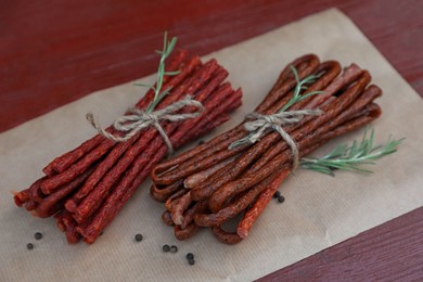 Tasty dry cured sausages (kabanosy) and spices on wooden table