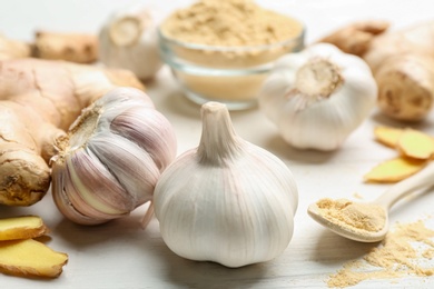 Ginger and fresh garlic on white table, closeup. Natural cold remedies