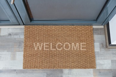 Door mat with word WELCOME near entrance, top view